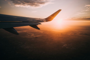 Mit dem Flugzeug in den Urlaub fliegen und aus dem Fenster den Sonnenuntergang sehen.